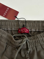 Dark gray Gucci shorts waistband with drawstring and logo; hanging brand tag