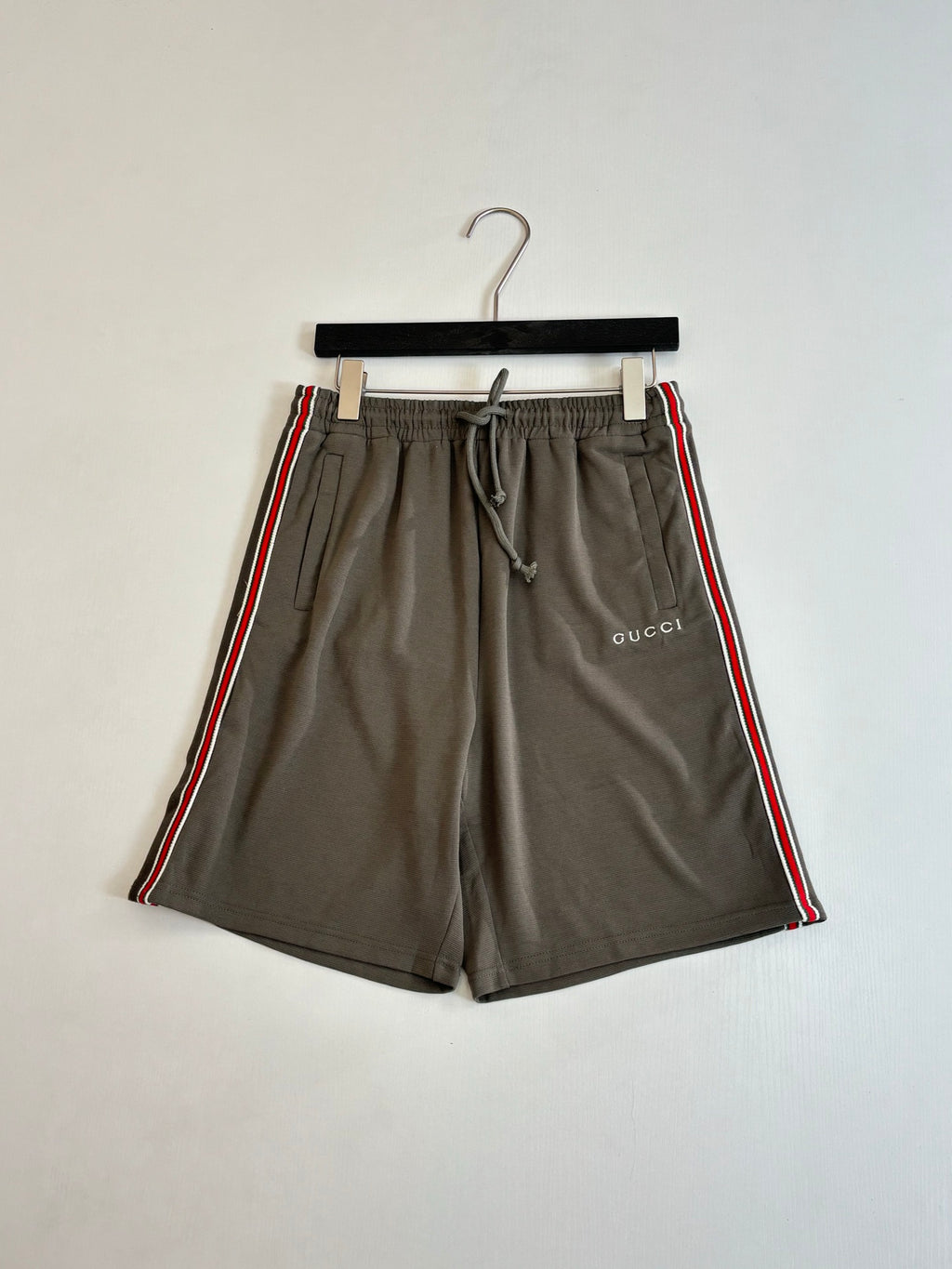 Dark gray Gucci drawstring shorts with side stripe and woven logo