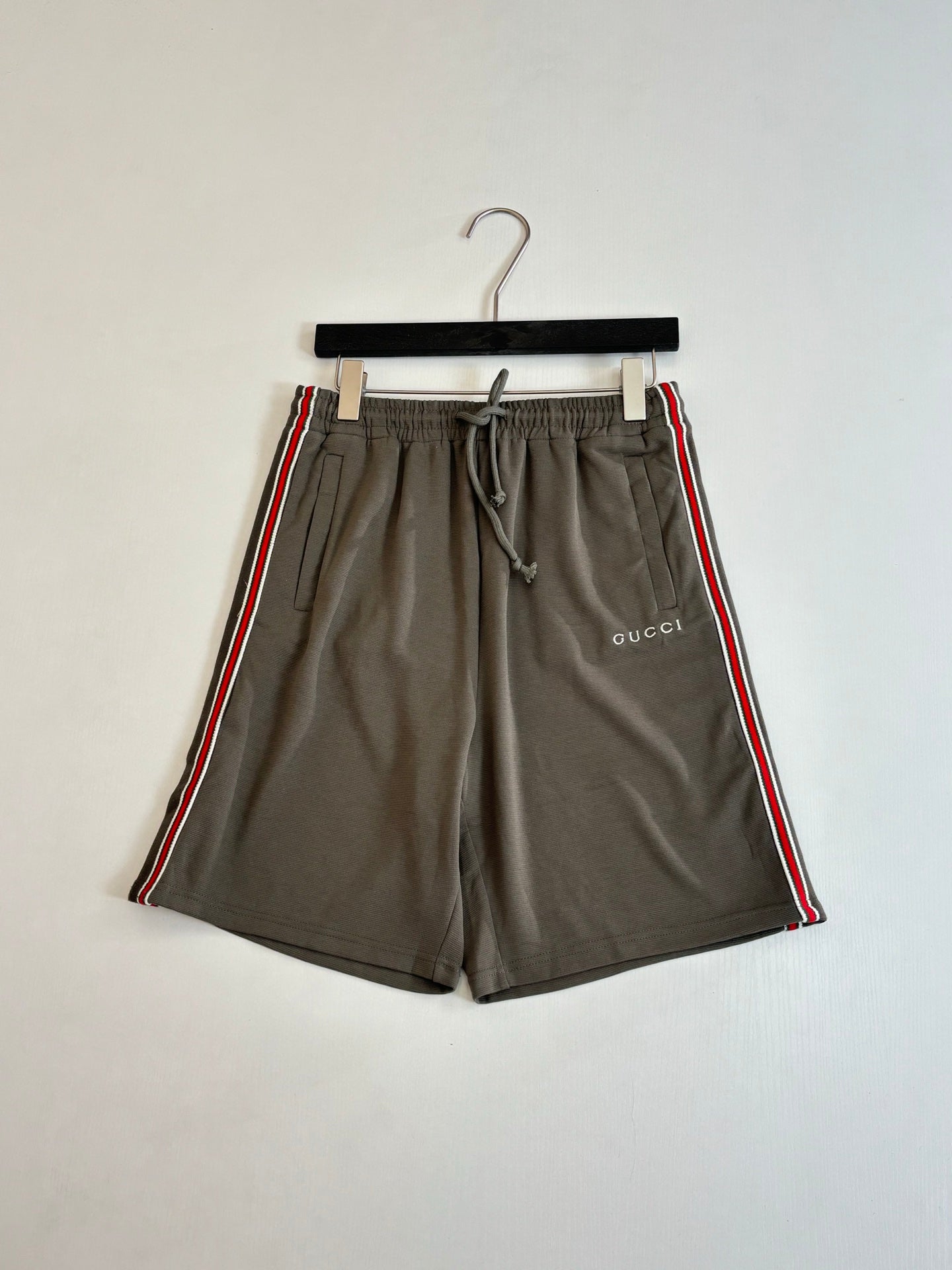 Dark gray Gucci drawstring shorts with side stripe and woven logo