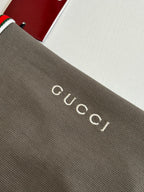 Gucci logo lettering on dark gray knit fabric of a short-sleeve shirt