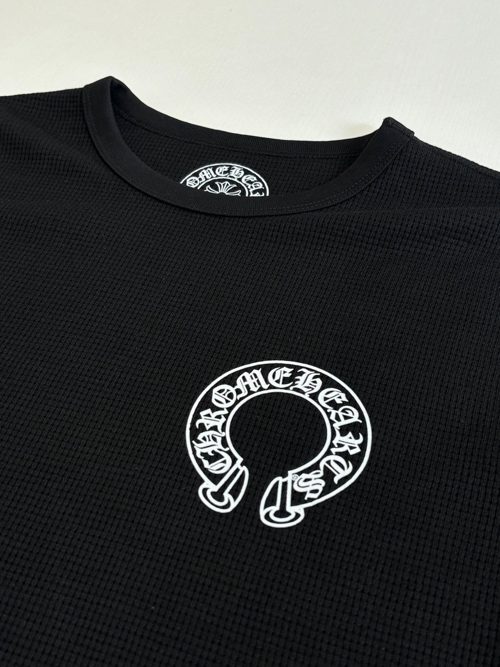 Black long-sleeve shirt with large white circular graphic at center chest