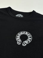 Black long-sleeve shirt with large white circular graphic at center chest