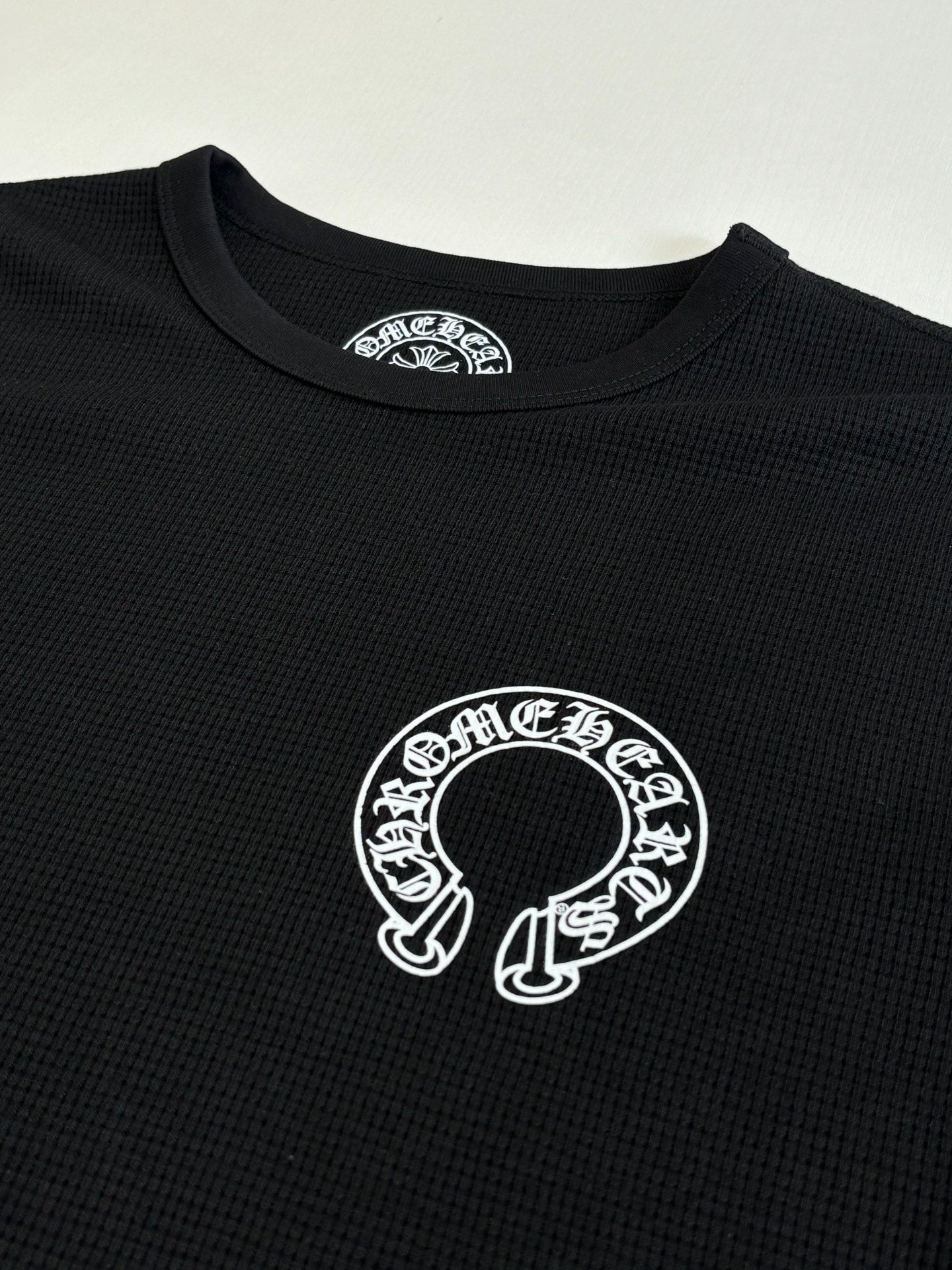 Black long-sleeve shirt with large white circular graphic at center chest