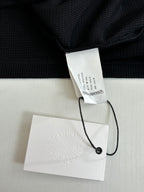 Black long-sleeve shirt with inner neck label and attached hang tags