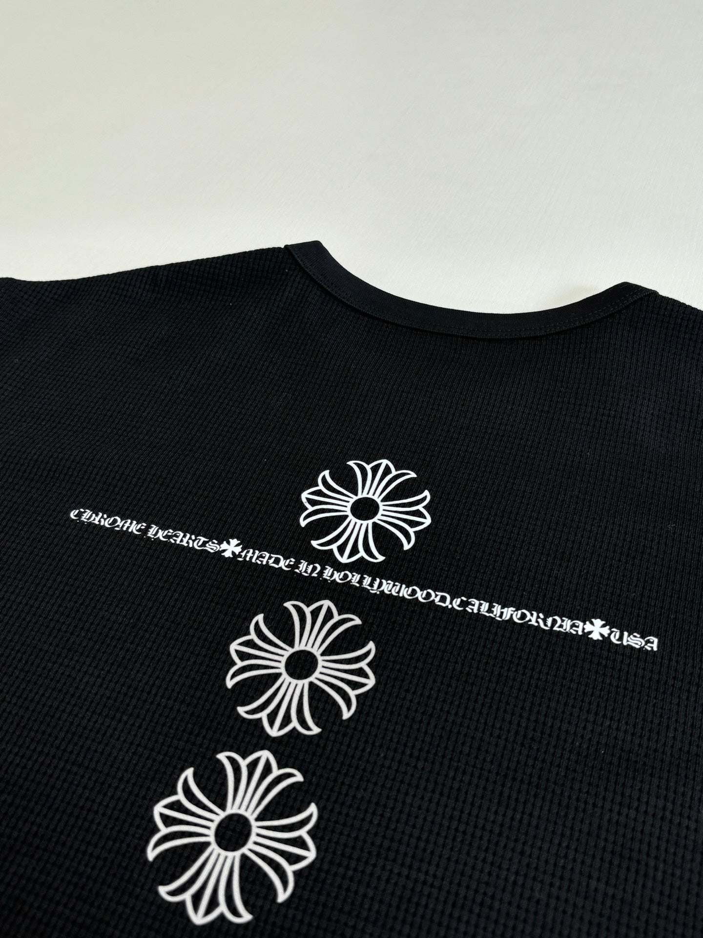 Black long-sleeve shirt with three white flower graphics on back