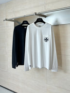 White and black long-sleeve T-shirts on hangers, each with a chest emblem.