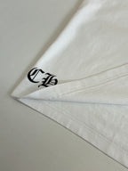 White T-shirt sleeve hem with black logo embroidery.