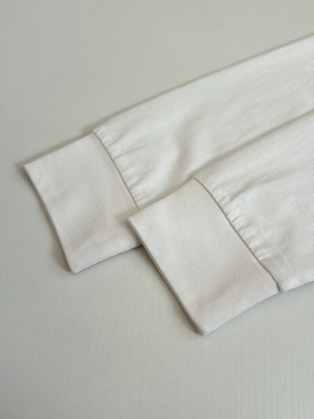 White T-shirt sleeve cuff and hem detail.