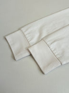 White T-shirt sleeve cuff and hem detail.