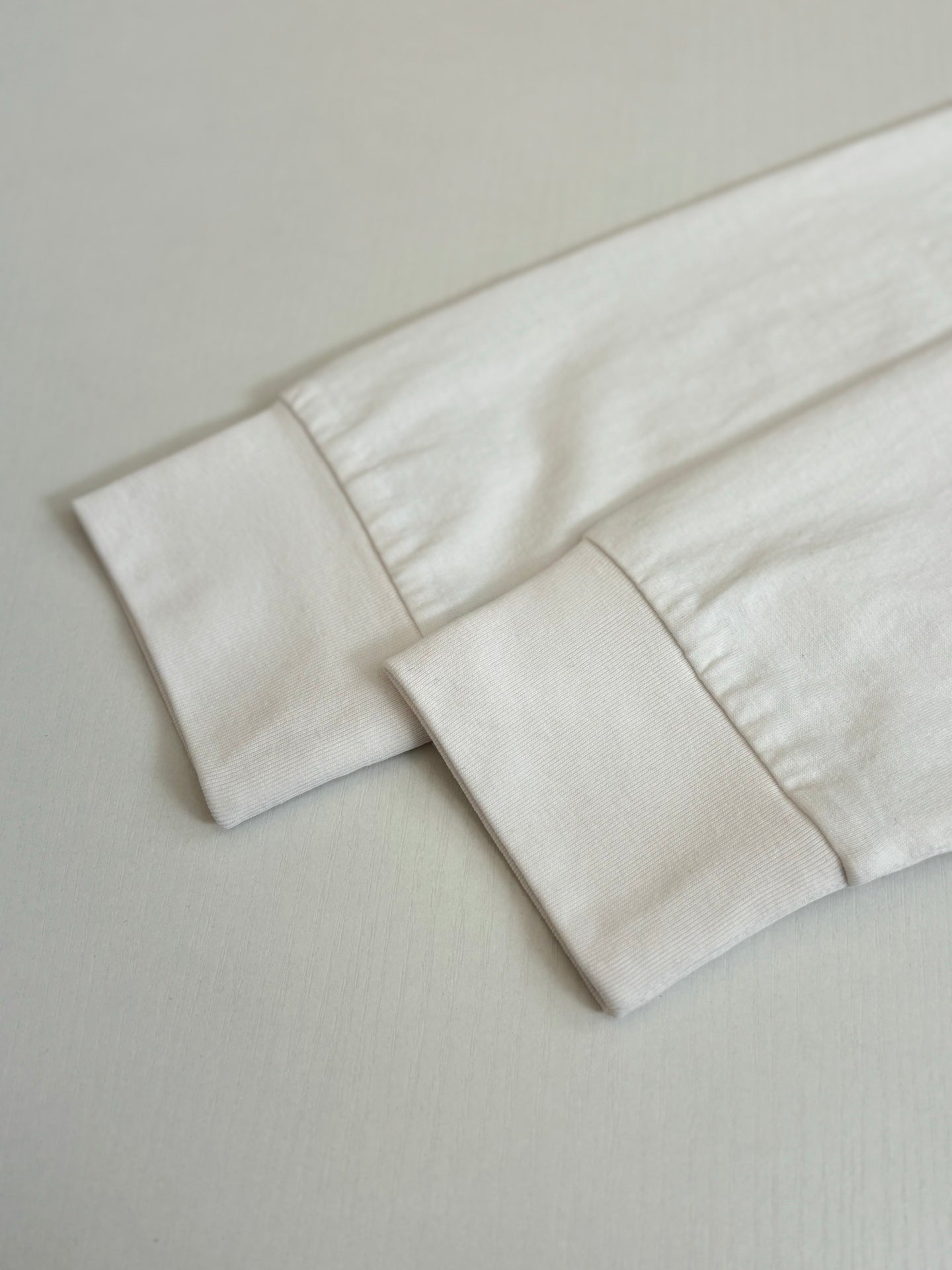 White T-shirt sleeve cuff and hem detail.