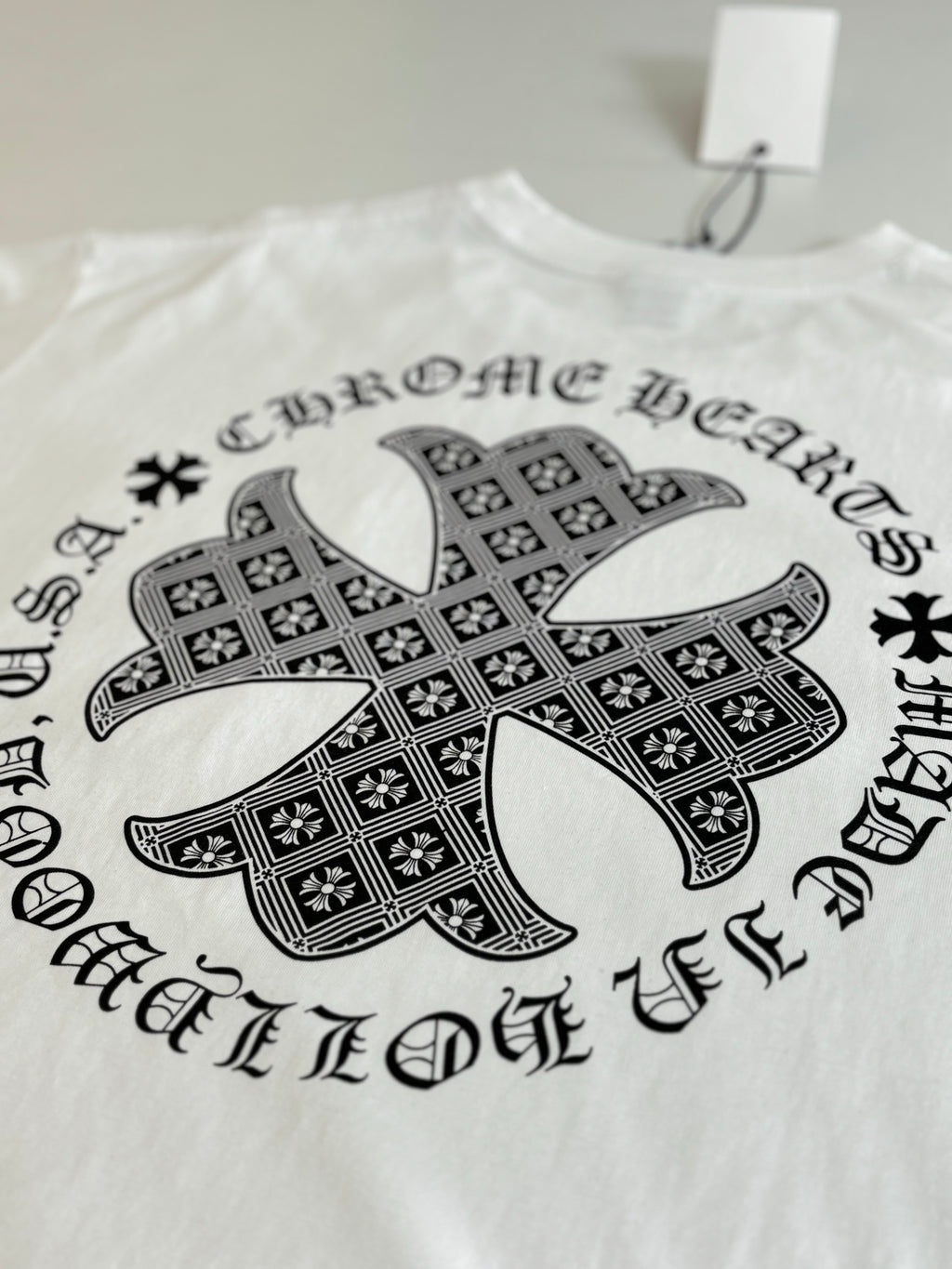 White long-sleeve T-shirt with large black cross graphic on front.