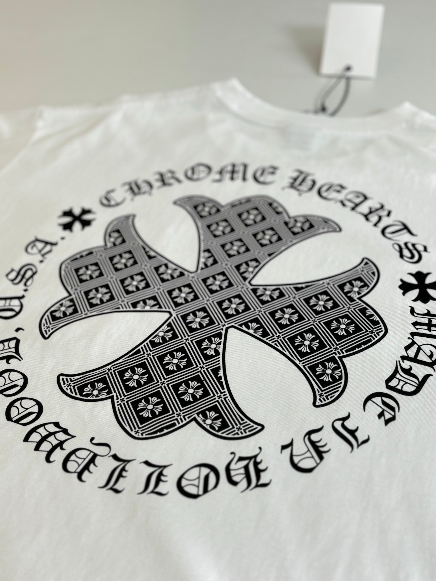 White long-sleeve T-shirt with large black cross graphic on front.