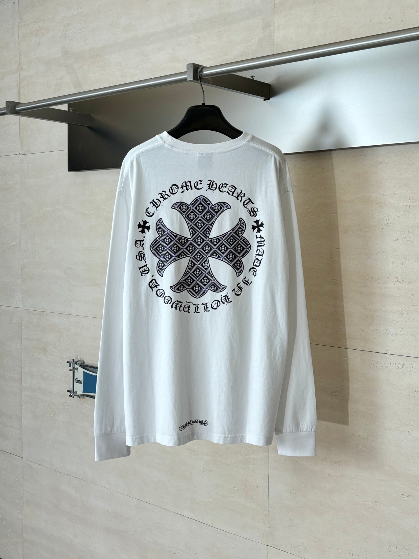 White long-sleeve T-shirt with large black cross-style graphic on back.