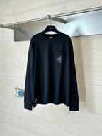 Black long-sleeve top with crew neck and chest logo graphic