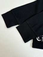 Black long-sleeve top with curved hem and partial sleeve logo