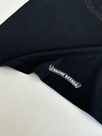 Black long-sleeve top with small embroidered logo at hem