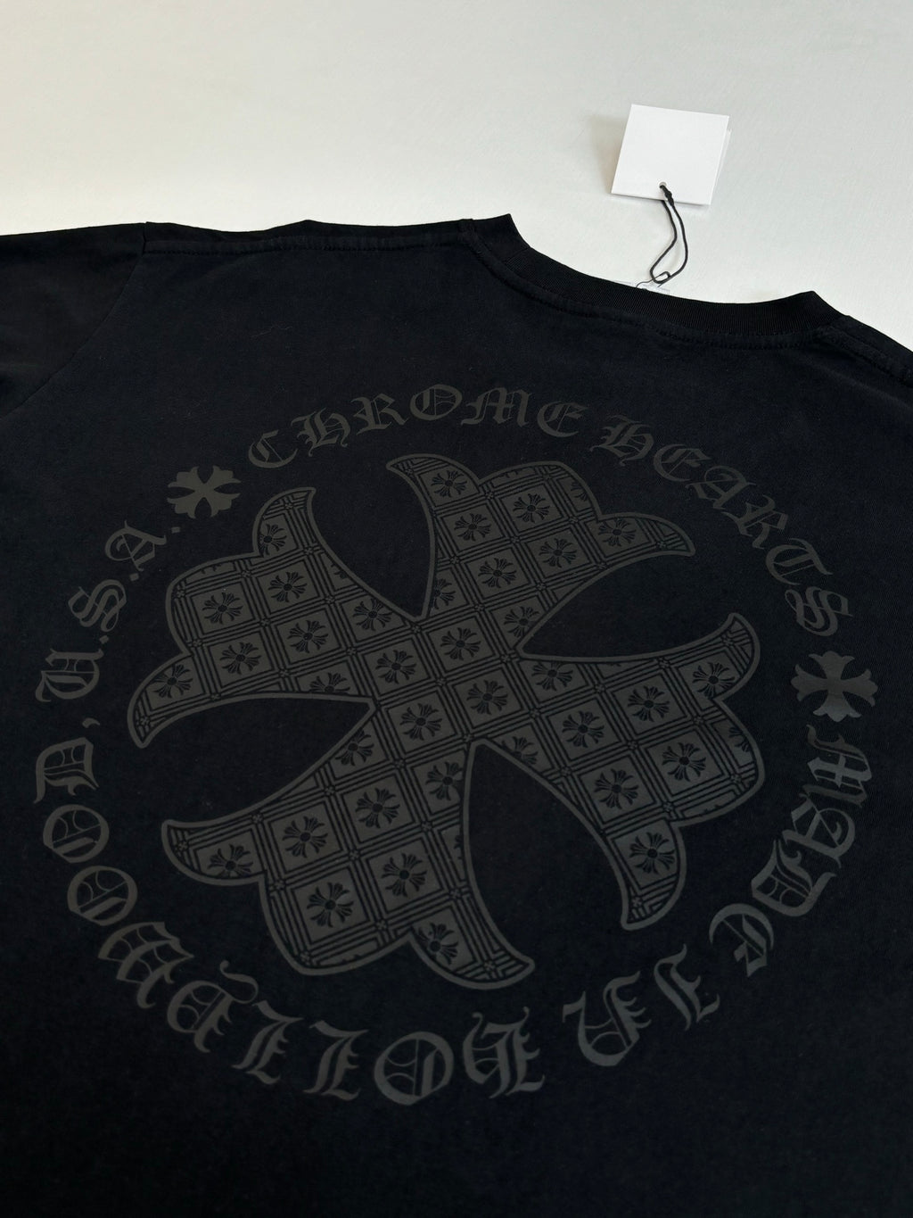 Black long-sleeve top with large cross-style back graphic