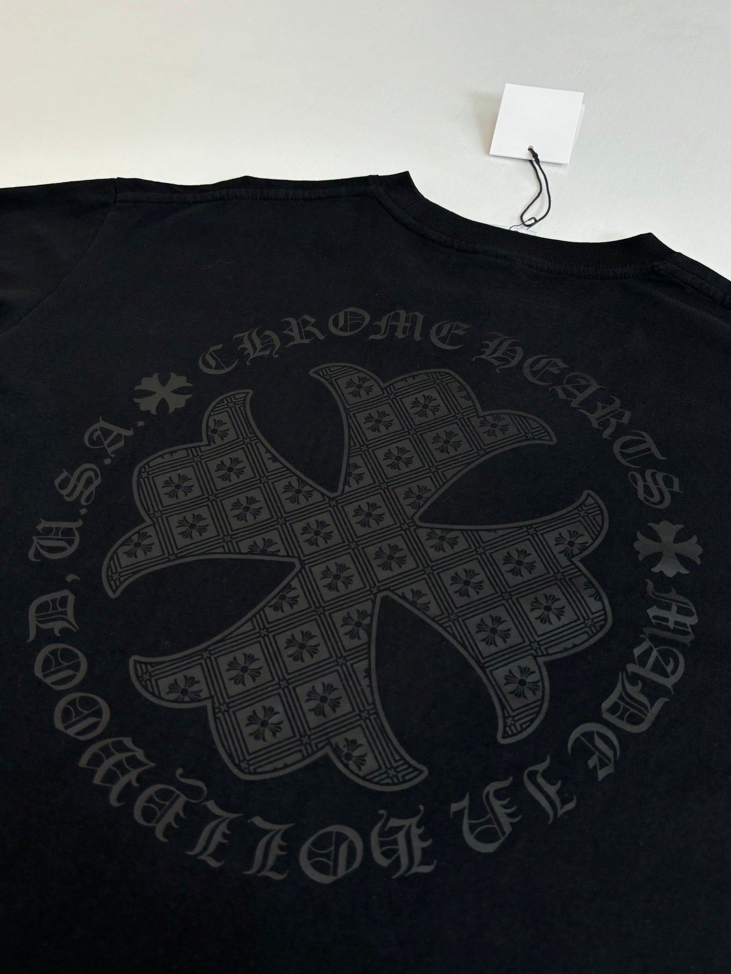 Black long-sleeve top with large cross-style back graphic