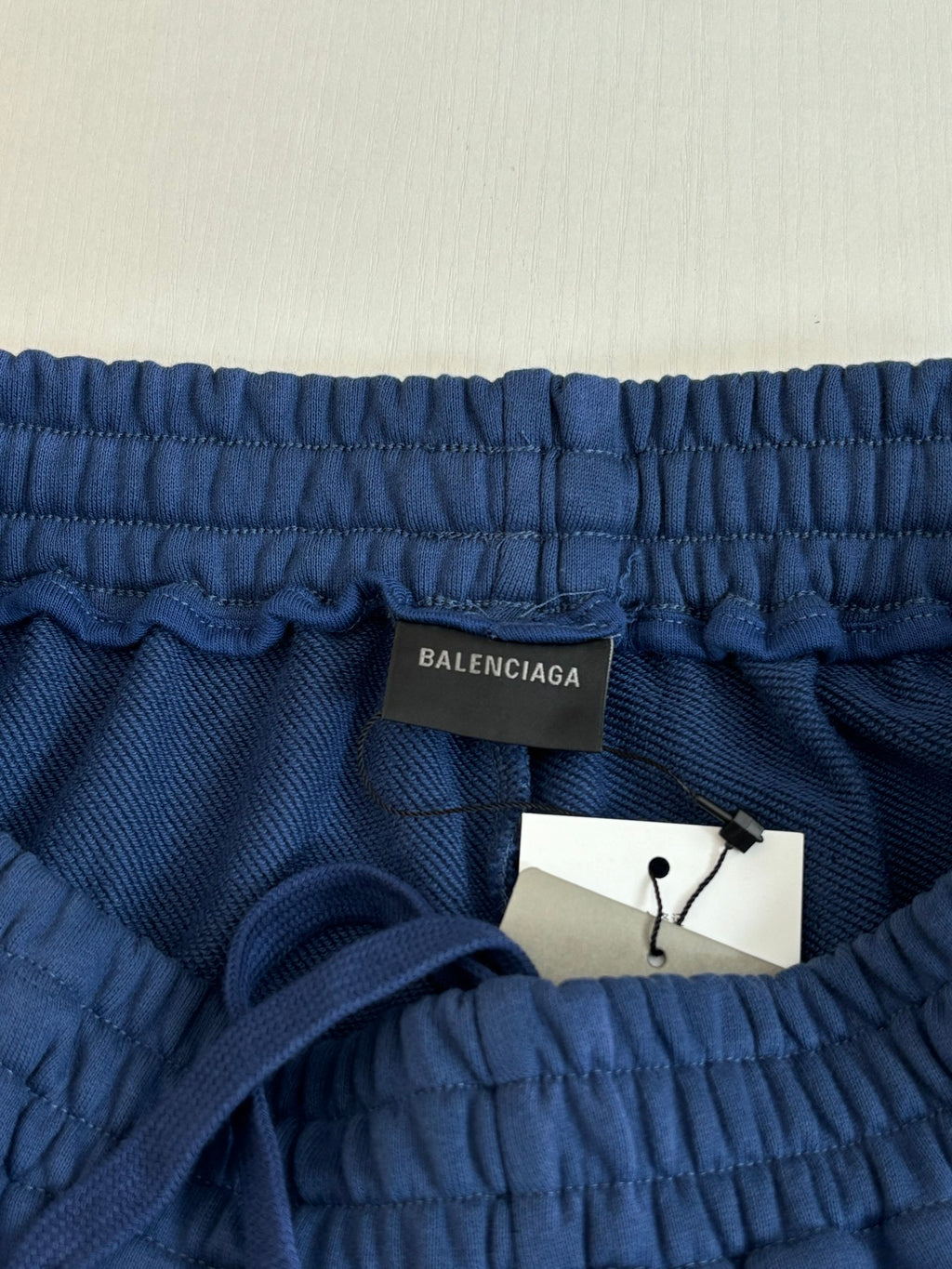 Blue elastic-waist shorts with Balenciaga label and attached white hang tag