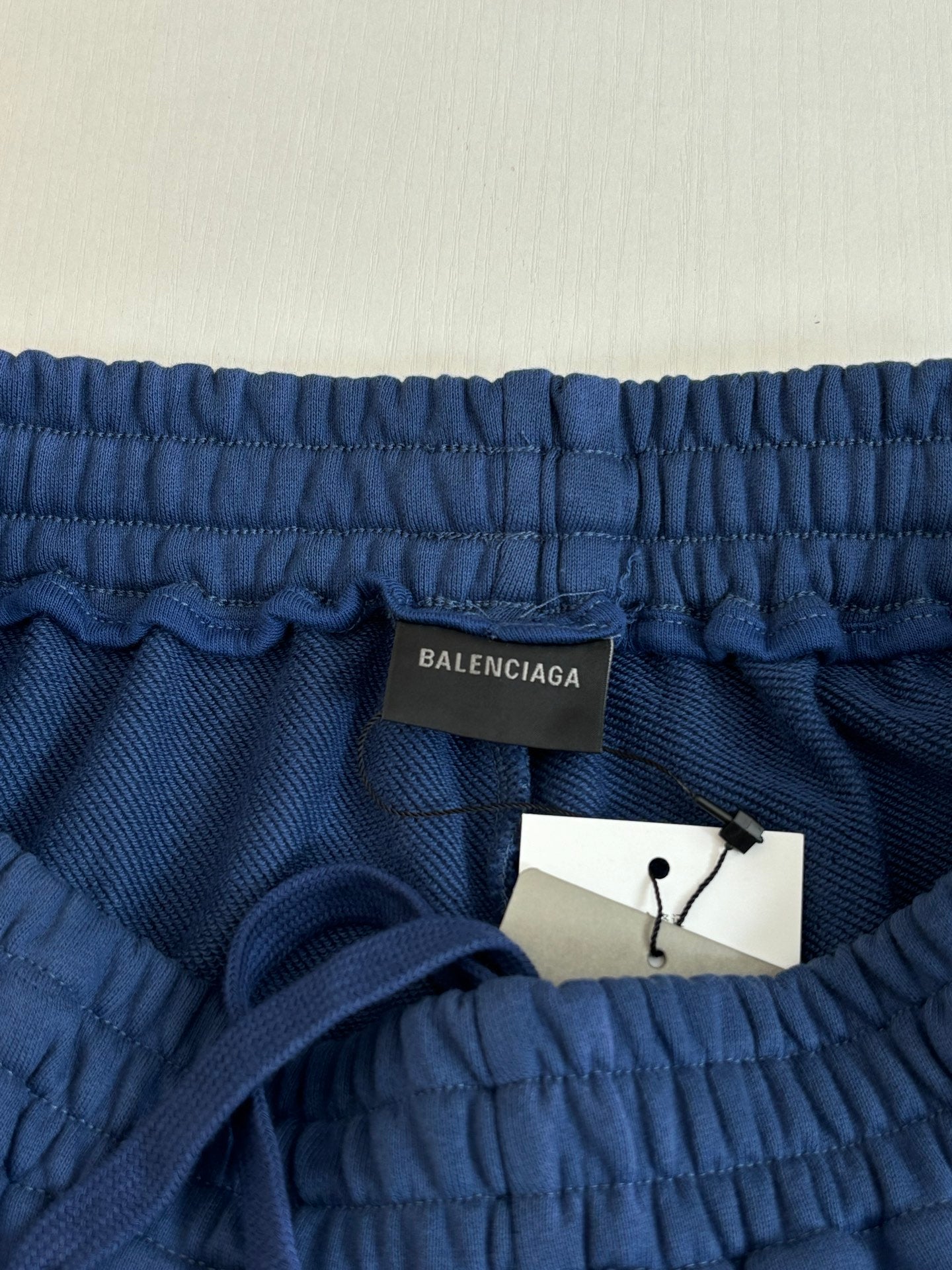 Blue elastic-waist shorts with Balenciaga label and attached white hang tag