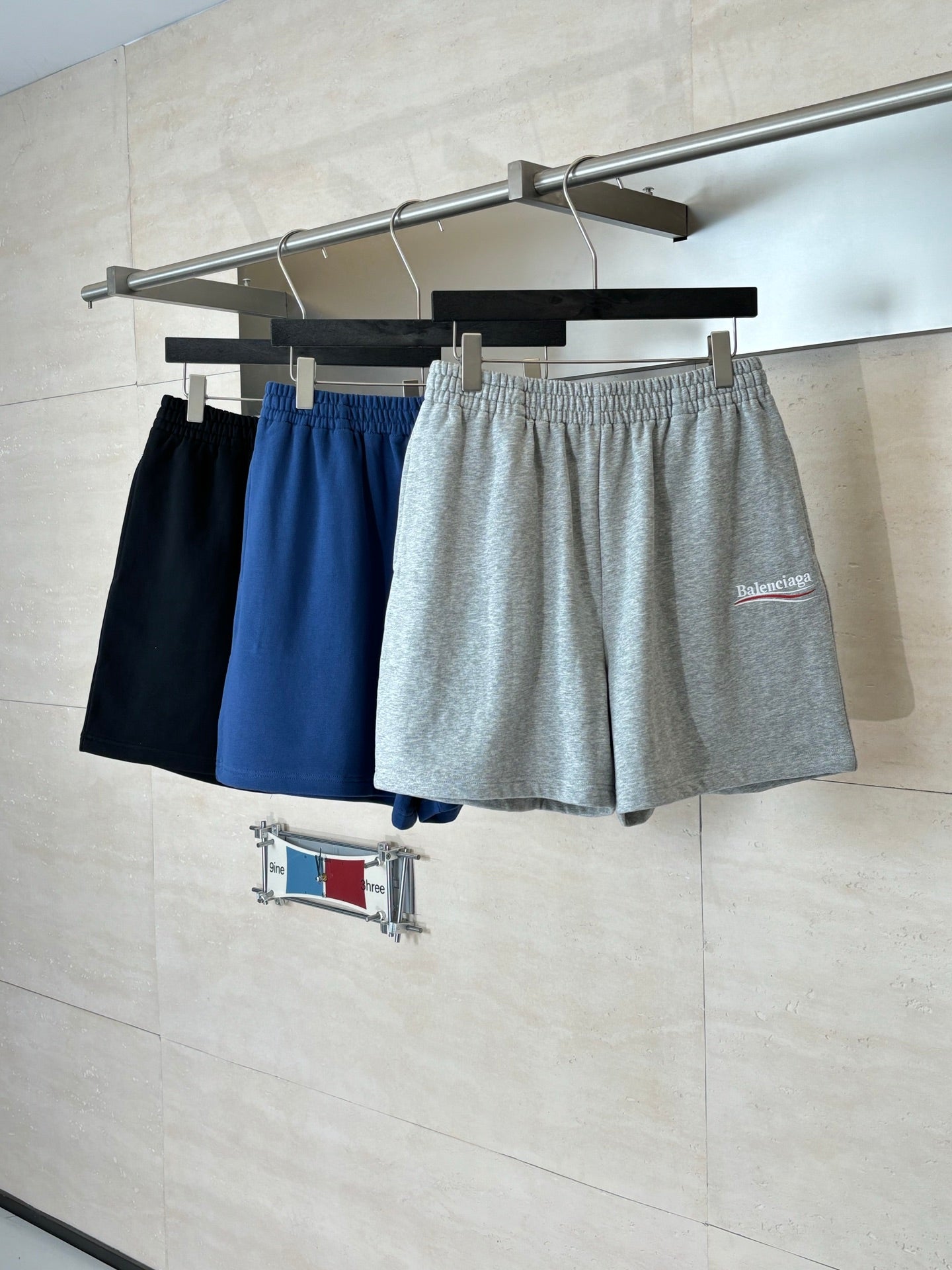 Assorted shorts on hangers: navy, blue, and gray heather with elastic waist and drawstring
