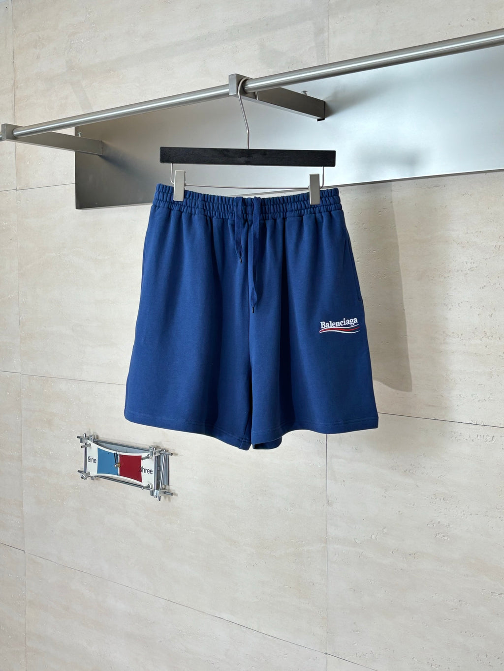 Blue Balenciaga drawstring shorts on hanger, front view with elastic waistband