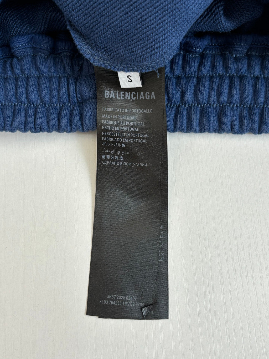 Blue shorts size and brand label on waistband area, care information tag shown