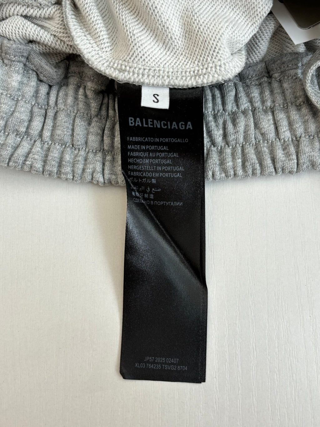 Black clothing tag on gray shorts waistband