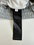 Black clothing tag on gray shorts waistband