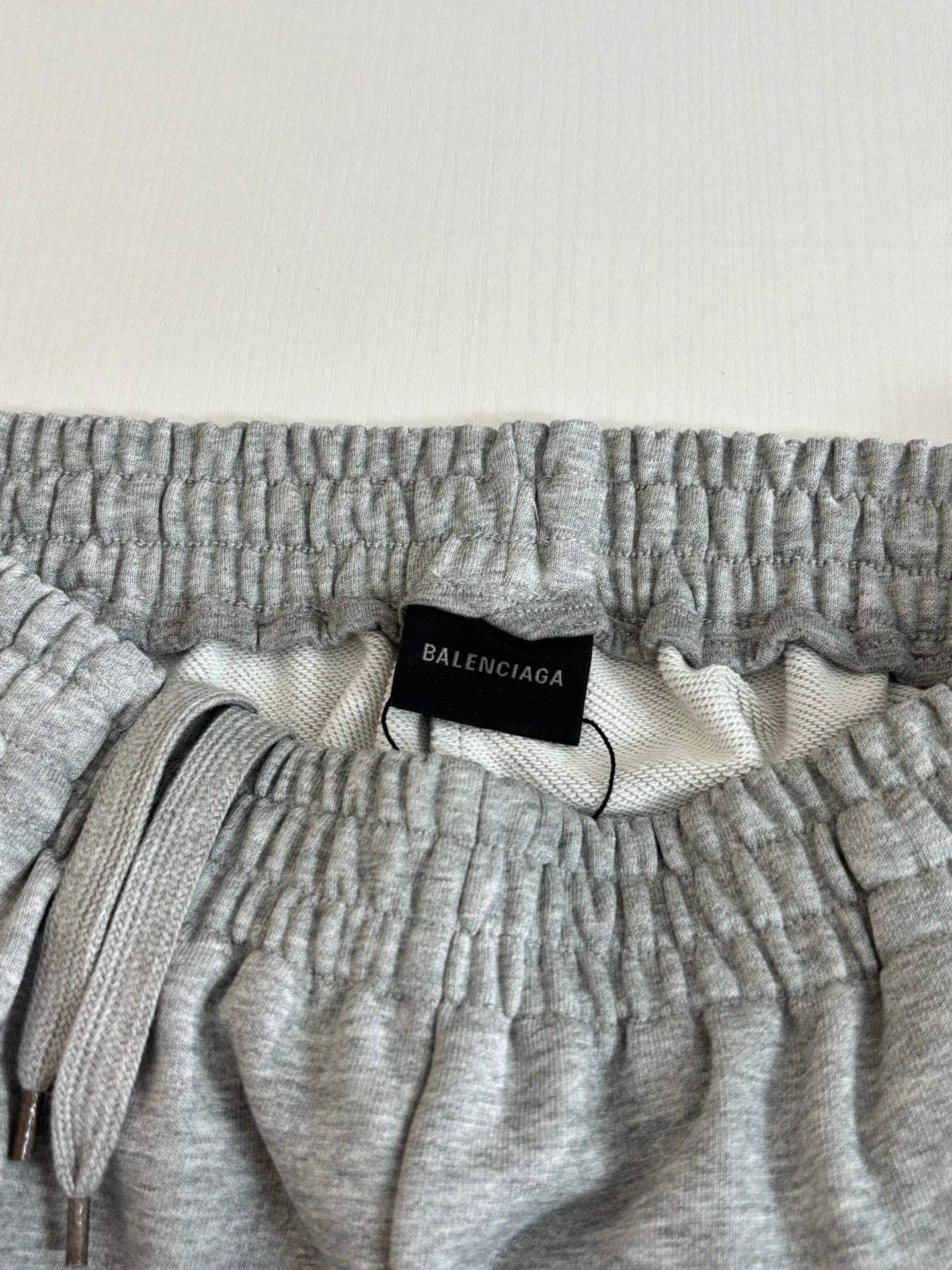 Gray heather shorts waistband close-up with black Balenciaga size label