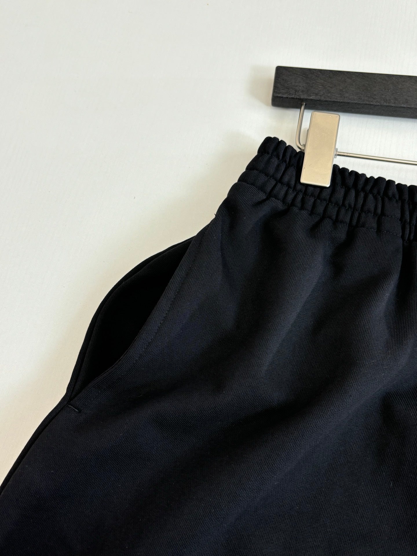 Black drawstring shorts waistband close-up with elastic and gathered fabric