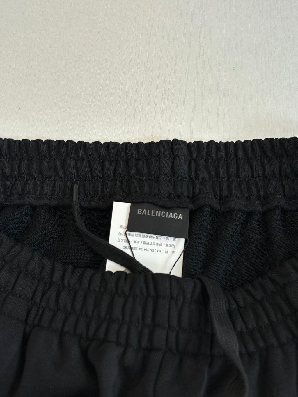 Black drawstring shorts waistband with attached Balenciaga size label