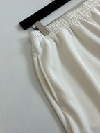 White Balenciaga shorts close-up with textured elastic waistband and stitched seams.