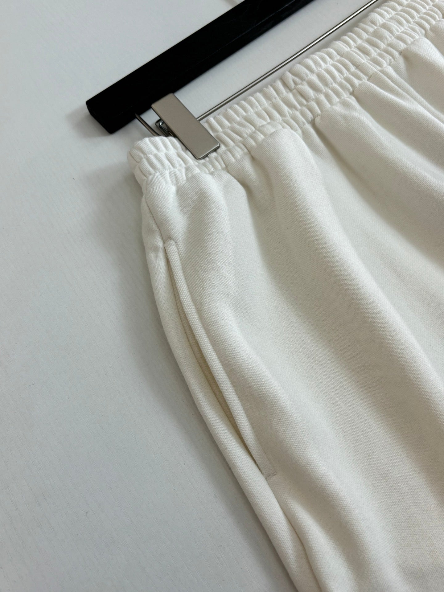 White Balenciaga shorts close-up with textured elastic waistband and stitched seams.