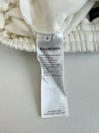 Balenciaga size S fabric tag on white shorts waistband, with product info text.