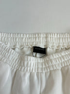 White Balenciaga shorts waistband close-up with gathered elastic and size tag label.