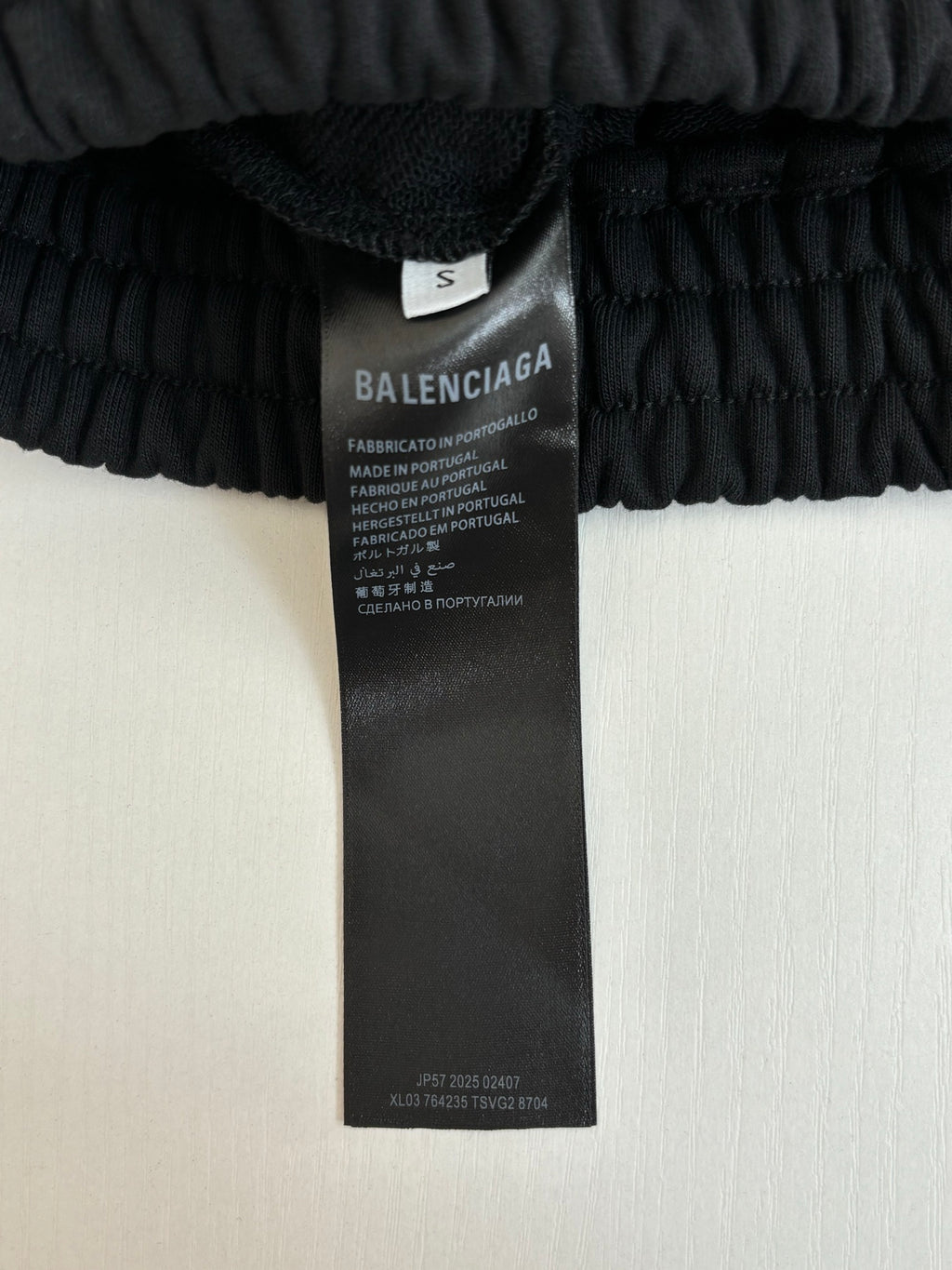 Black shorts care label tag on elastic waistband, size S marked on inner label