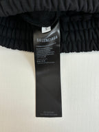 Black shorts care label tag on elastic waistband, size S marked on inner label