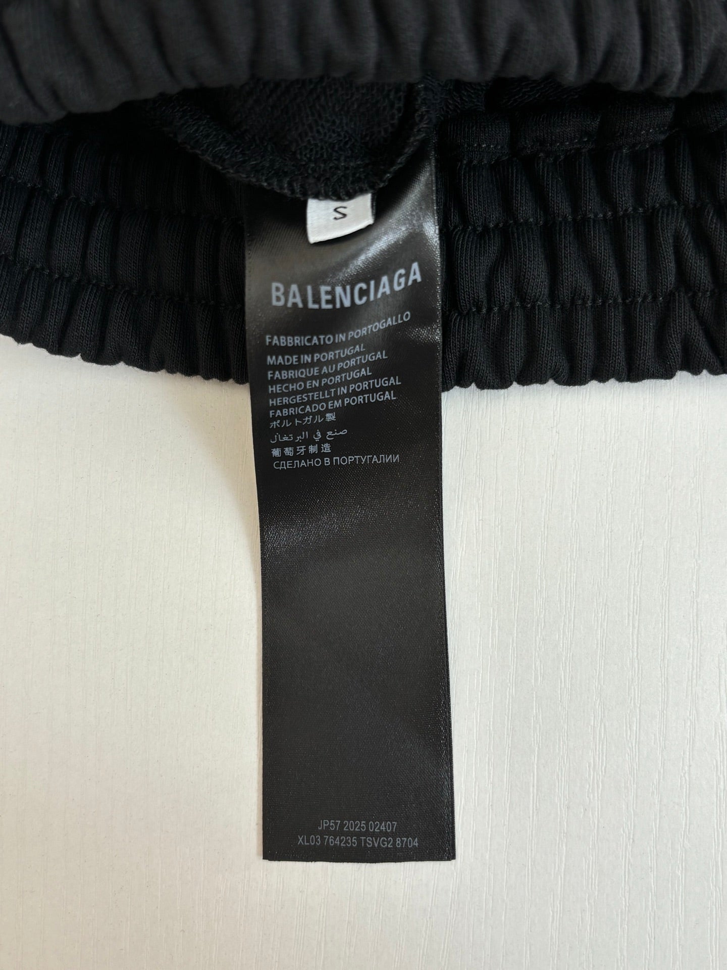Black shorts care label tag on elastic waistband, size S marked on inner label