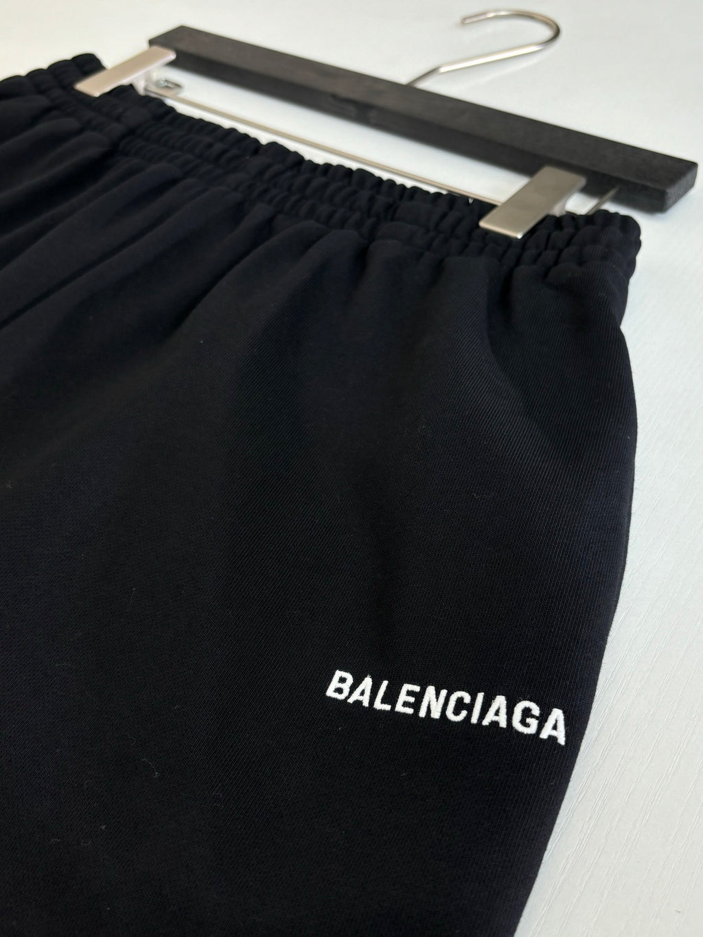 Black shorts close-up with elastic waistband and BALENCIAGA logo printed on leg