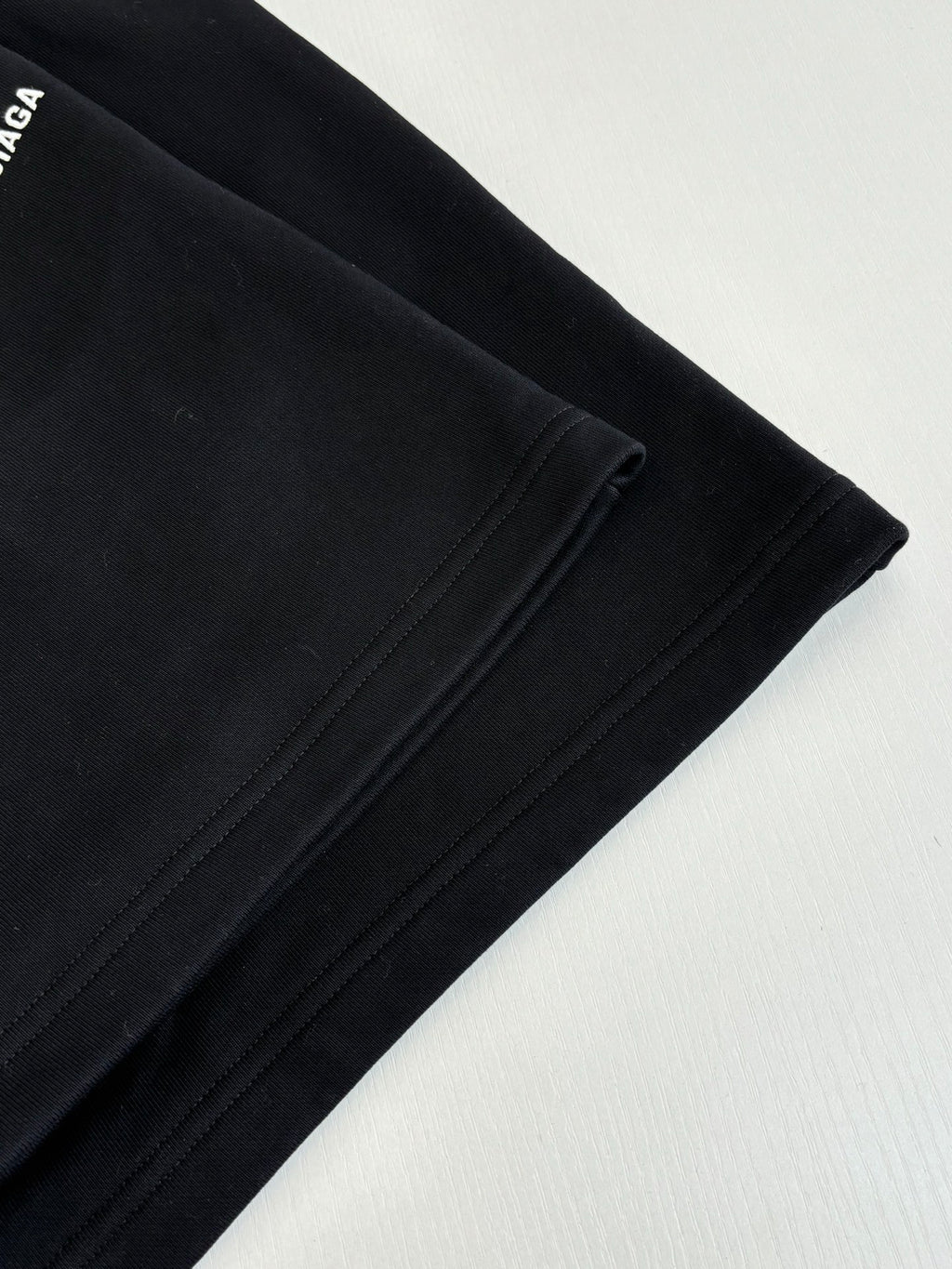 Black shorts fabric with side seam stitching and angled hem view