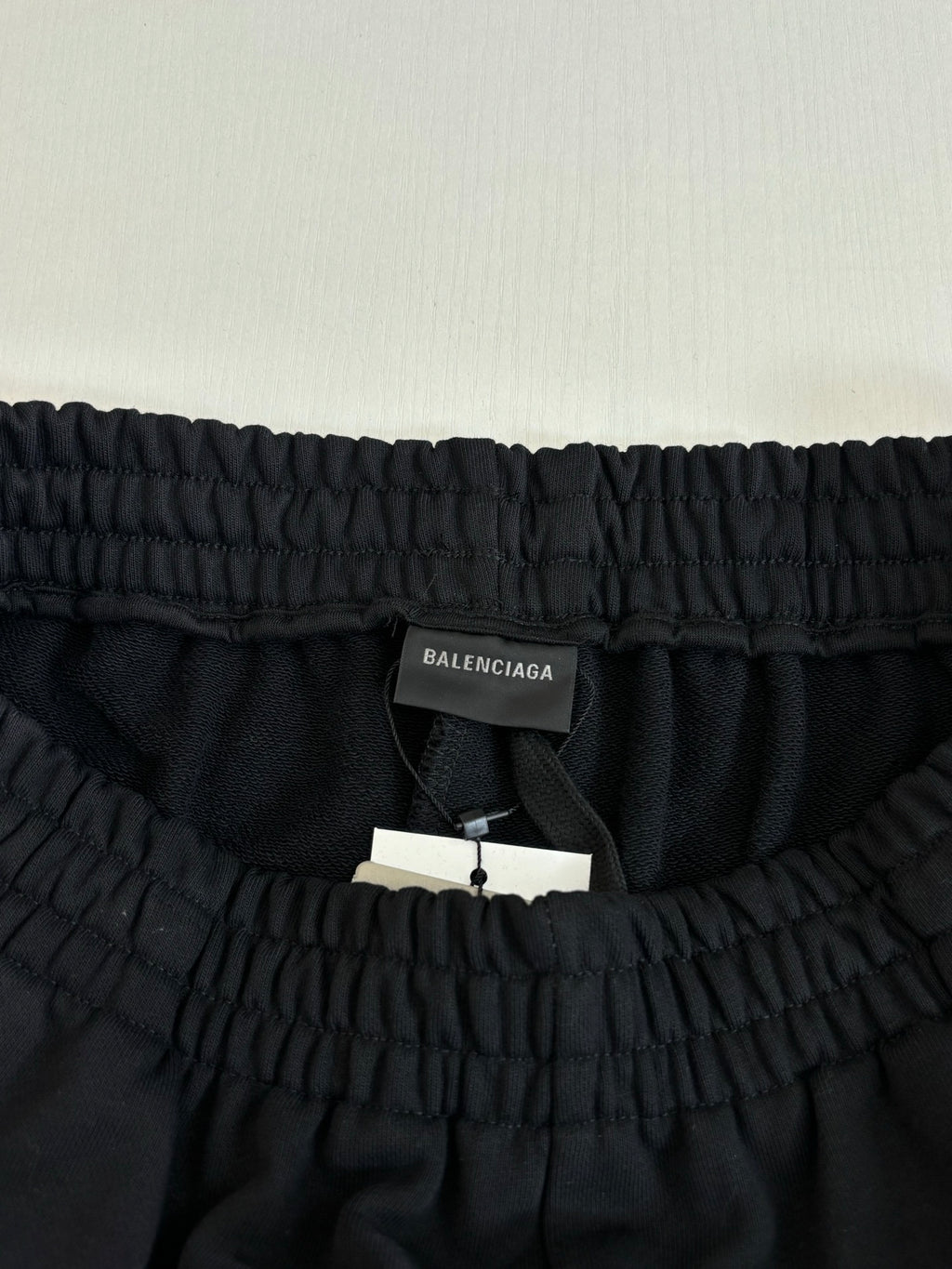 Elastic waistband of black shorts with inner tag and hang label