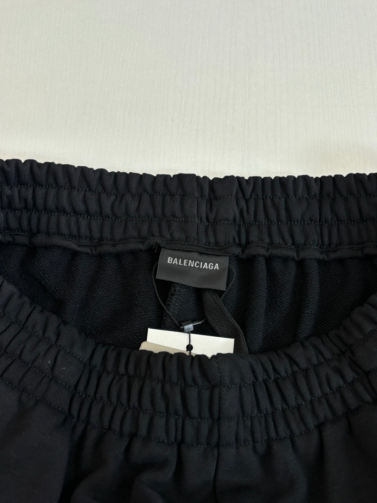 Elastic waistband of black shorts with inner tag and hang label