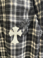 Detail view of black-and-white plaid fabric with white cross applique patch