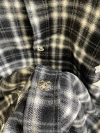 Close-up of plaid button area with decorative metal button on garment