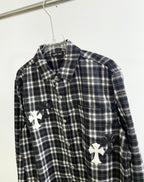 Close-up of black and white plaid button-up with white cross appliques on front