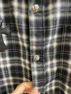 Close-up of black-and-white plaid shirt front with gold-toned buttons