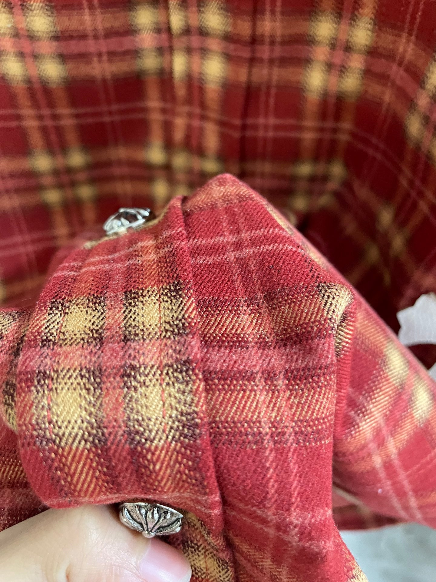 Red plaid shirt back with yoke stitching and small metal button