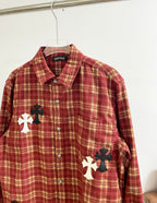 Red plaid long-sleeve shirt front with button placket and large cross patch