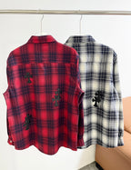 Red plaid button-up shirt showing back view with black embroidered motifs